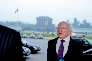 President Michael D. Higgins as he leaves the National Assembly answering questions from the media with the Ho Chi Minh Mausoleum in the background