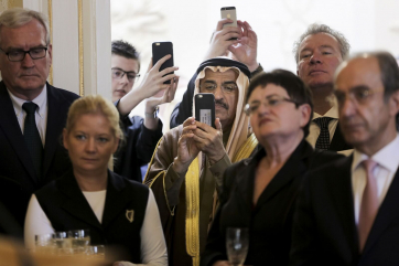 The United Arab Emirates Ambassador H.E Dr. Saeed Mohammed Al-Shamsi taking a photograph with his phone.