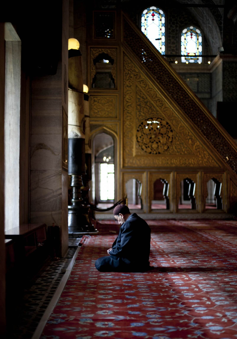 A man sits and prays by a window during President Michael D Higgins and his wife Sabina's visit to the Blue Mosque in Istanbul
